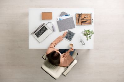 Femme utilisant une tablette et un ordinateur portable sur un bureau moderne et organisé
