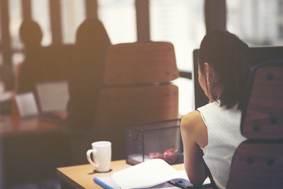Femme assise à un bureau dans un espace de coworking lumineux et moderne
