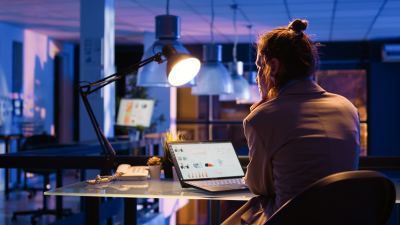 Femme concentrée travaillant tard le soir dans un bureau moderne et bien organisé