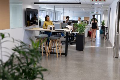 Espace de coworking lumineux avec bureaux debout, sièges ergonomiques et plantes