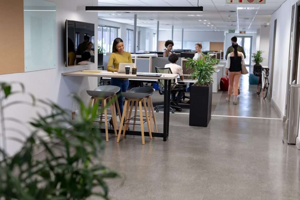 Espace de coworking lumineux avec bureaux debout, sièges ergonomiques et plantes