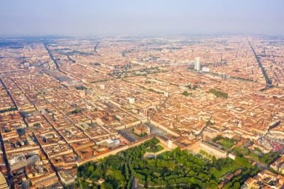 Vue aérienne de Turin montrant un urbanisme dense avec des bâtiments historiques et des espaces verts.