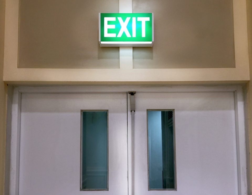 Porte de sortie de secours avec panneau lumineux EXIT et vitres verticales