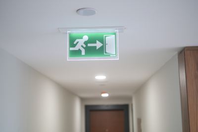 Panneau lumineux de sortie de secours vert installé au plafond d'un couloir professionnel