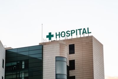 Façade d'un bâtiment hospitalier moderne avec panneau lumineux et croix verte