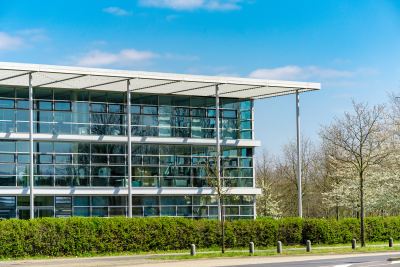 Immeuble de bureaux moderne avec façade en verre et espaces verts aménagés