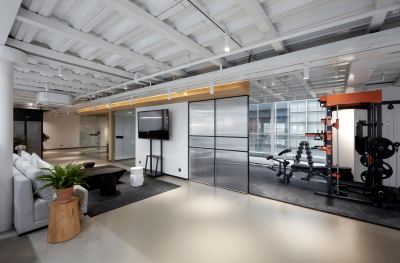 Espace de travail moderne combinant salle de sport, canapé et équipements de fitness