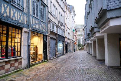 Rue pavée typique du centre historique de Rouen avec bâtiments à colombages et façades modernes