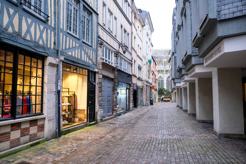 Rue pavée typique du centre historique de Rouen avec bâtiments à colombages et façades modernes