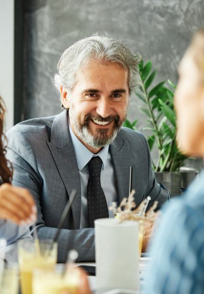 Homme en costume gris discutant lors d'une réunion dans un espace de coworking convivial