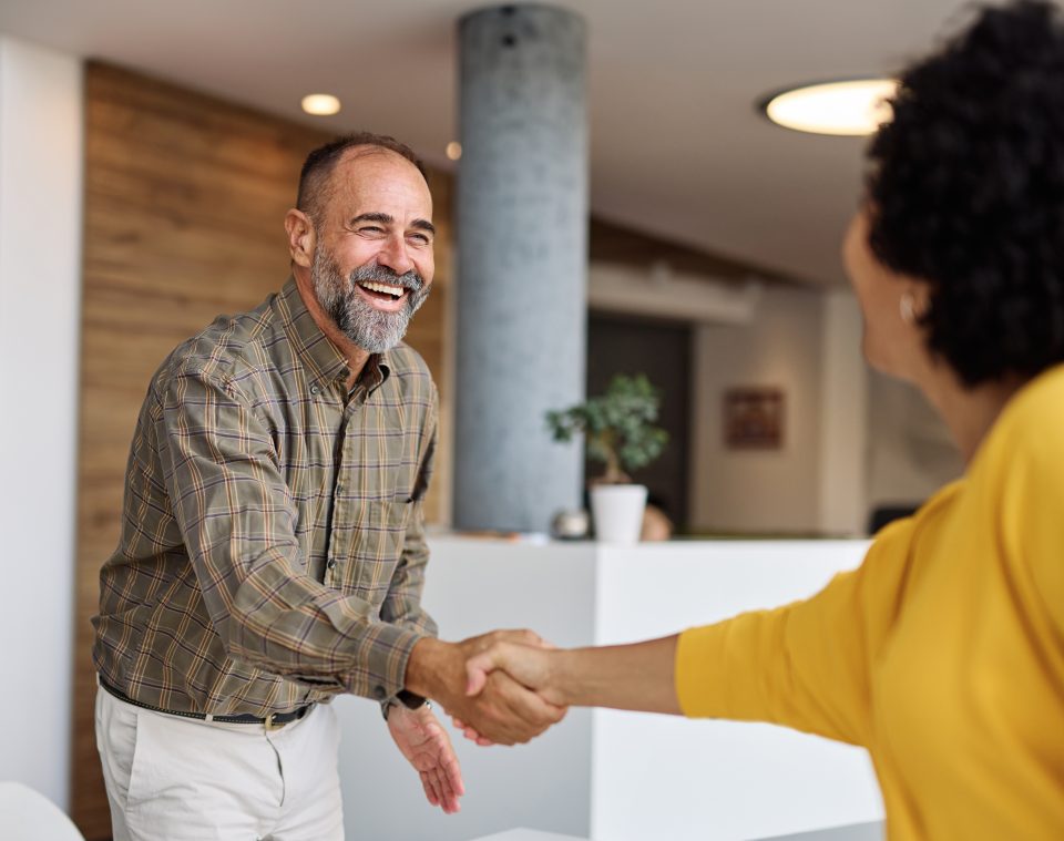 Deux professionnels se saluant dans un bureau moderne et lumineux