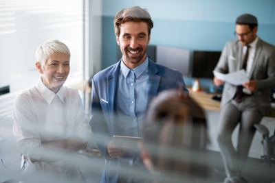 Trois professionnels discutant dans un espace de coworking lumineux et bien équipé