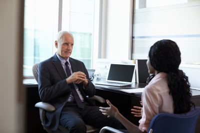 Un homme en costume conseille une femme dans un bureau moderne et lumineux