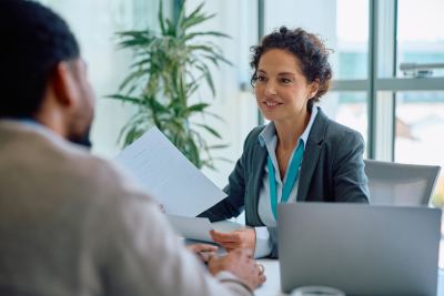 Une femme discute avec un client dans un espace de coworking lumineux et moderne