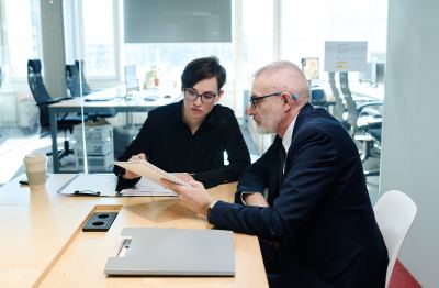 Deux professionnels discutent dans un espace de coworking lumineux et moderne.